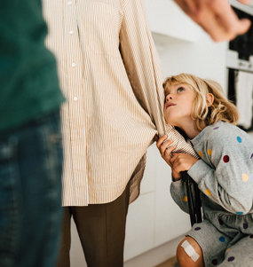 Två vuxna står mitt emot varandra. Ett barn drar i den ena vuxnas arm och tittar oroligt uppåt.