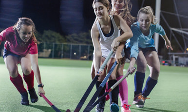 Tjejer spelar innebandy.