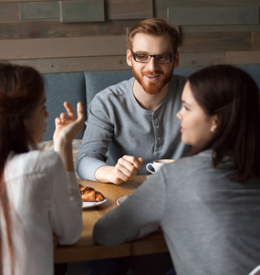 Fem personer samtalar runt ett bord