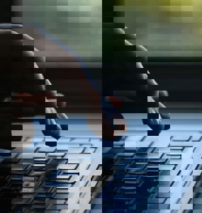 Hand i färd med att skriva på en laptop.