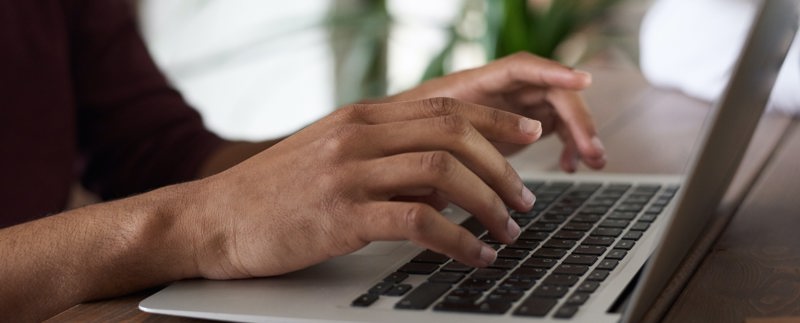 Fingrar skriver på en laptop