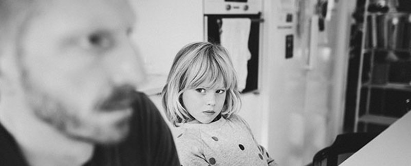 Barn i fokus tittar argt på sin pappa som också är arg och tittar ut ur bilden