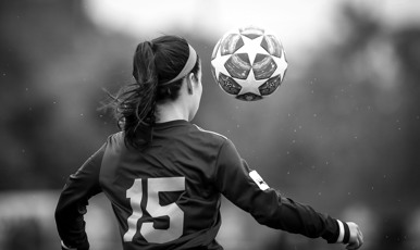 En kvinnlig fotbollsspelare och en boll dekorerad med stjärnor