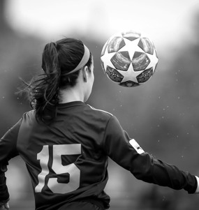 En kvinnlig fotbollsspelare och en boll dekorerad med stjärnor